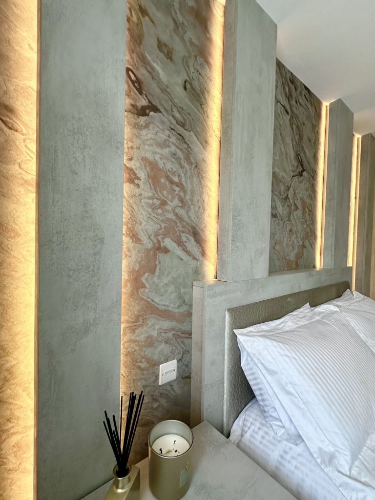 Bedside detail against the illuminated stone panelling