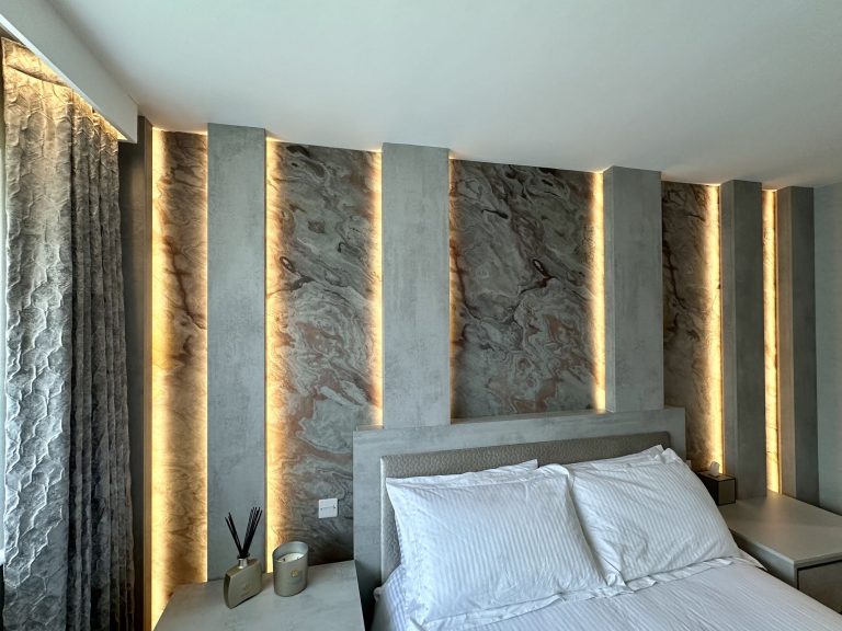 Lit slate veneer wall panels seen along the bed