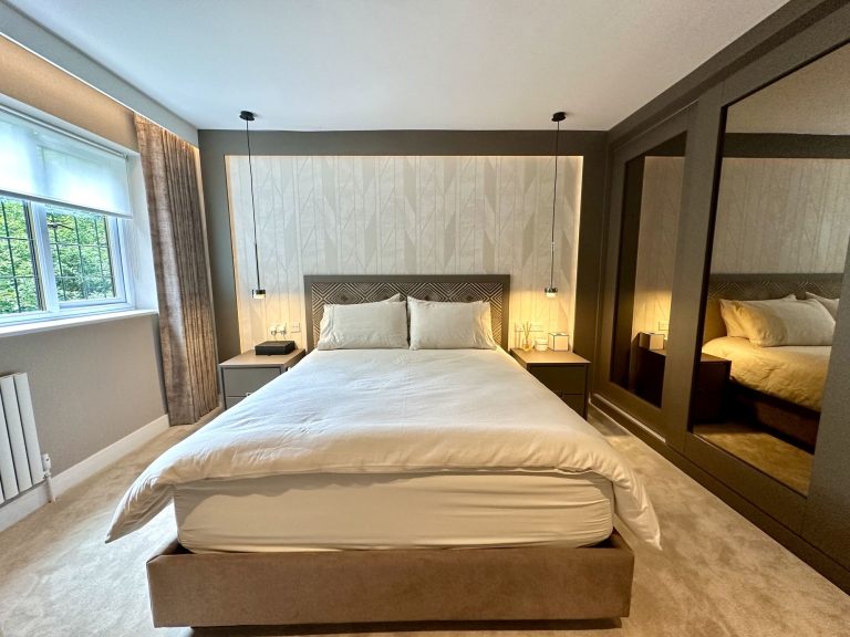 Roman blind and pendant lighting in a compact bedroom