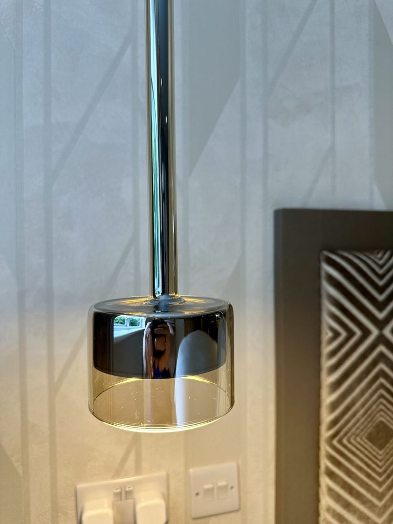 Pendant light hanging beside the textured wall panel