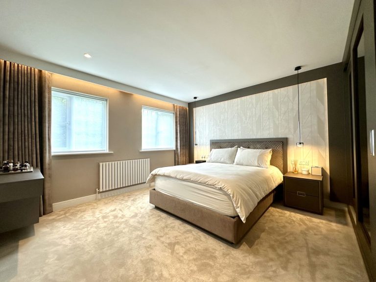 Second bedroom with framed textured wallpaper behind the bed