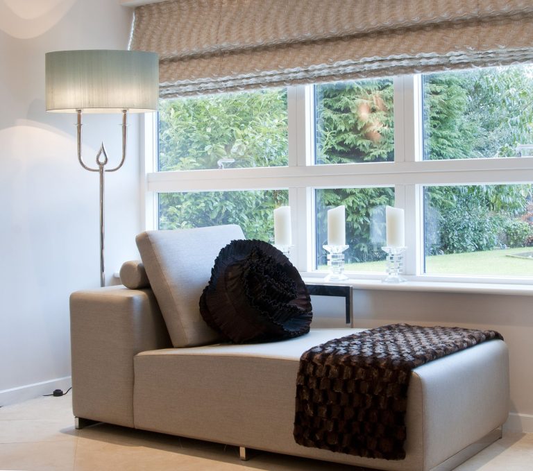 Window seating below a Roman blind in a light bedroom