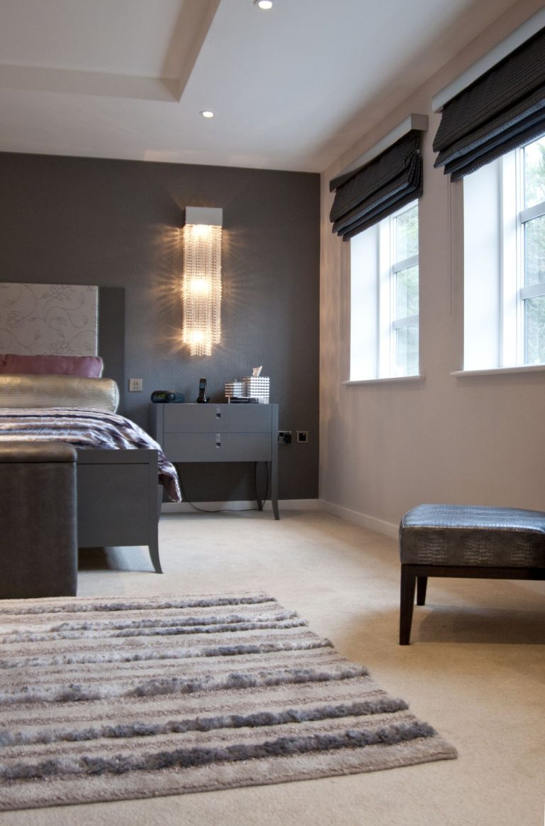 Dressing area with a lit mirror and an upholstered stool