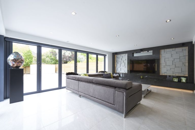Living room with full-height glazing to the garden and a linear fire