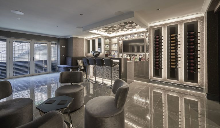 Basement bar and seating with the wine wall lit