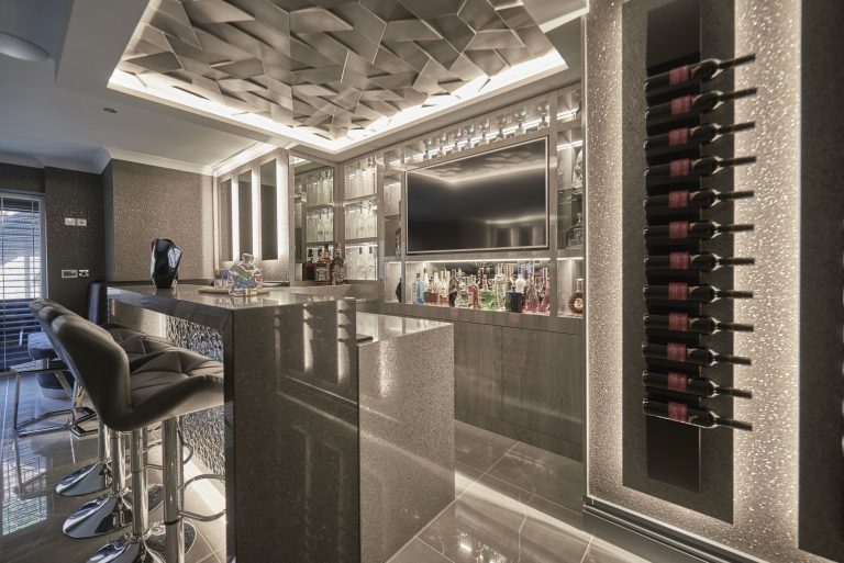 Basement bar with a three-dimensional ceiling panel and a lit wine display