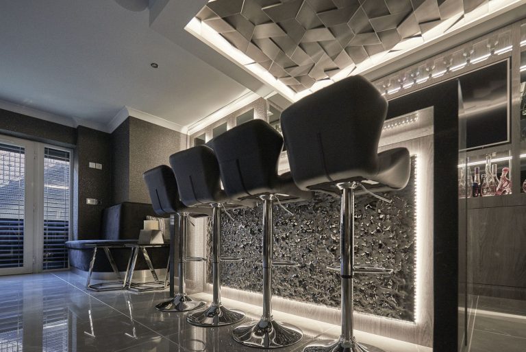 Bar stools at a textured glass bar front lit from behind
