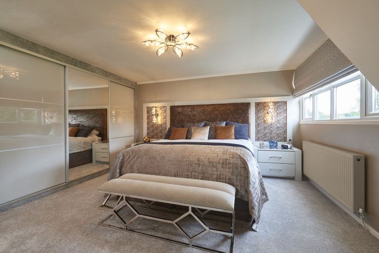 Copper textured wall covering behind the bed in a cottage bedroom