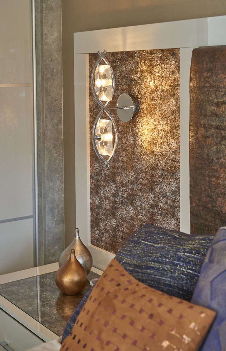 Detail of a copper textured wall covering beside a mirrored wardrobe