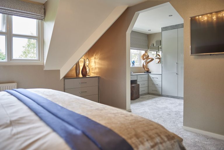 Bedroom with a television and fitted storage in the eaves