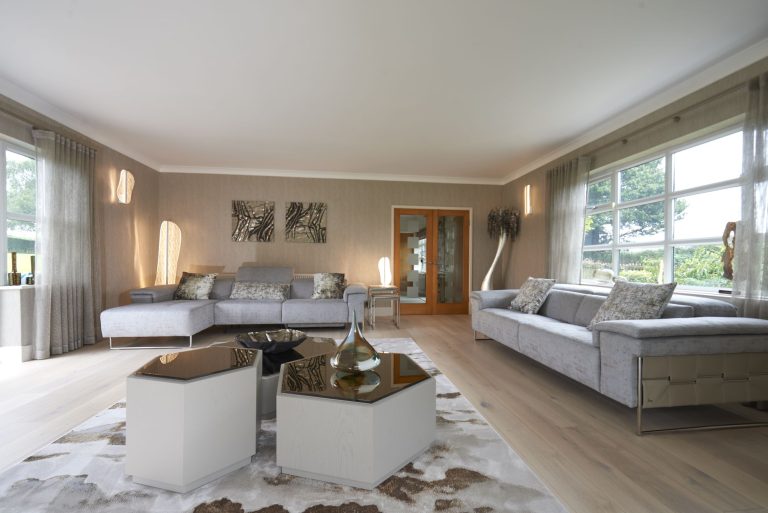 Two sofas facing across a textured rug in the cottage lounge